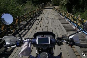 Mit dem Motorrad über eine Holzbrücke